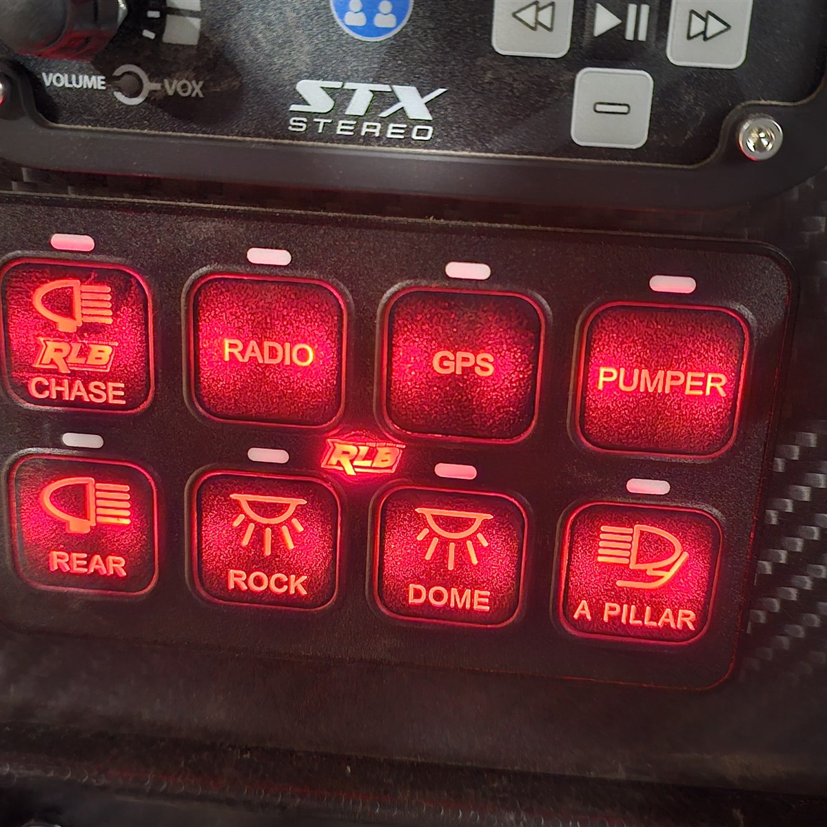 PRO8 switch panel glowing red in a carbon fiber dash